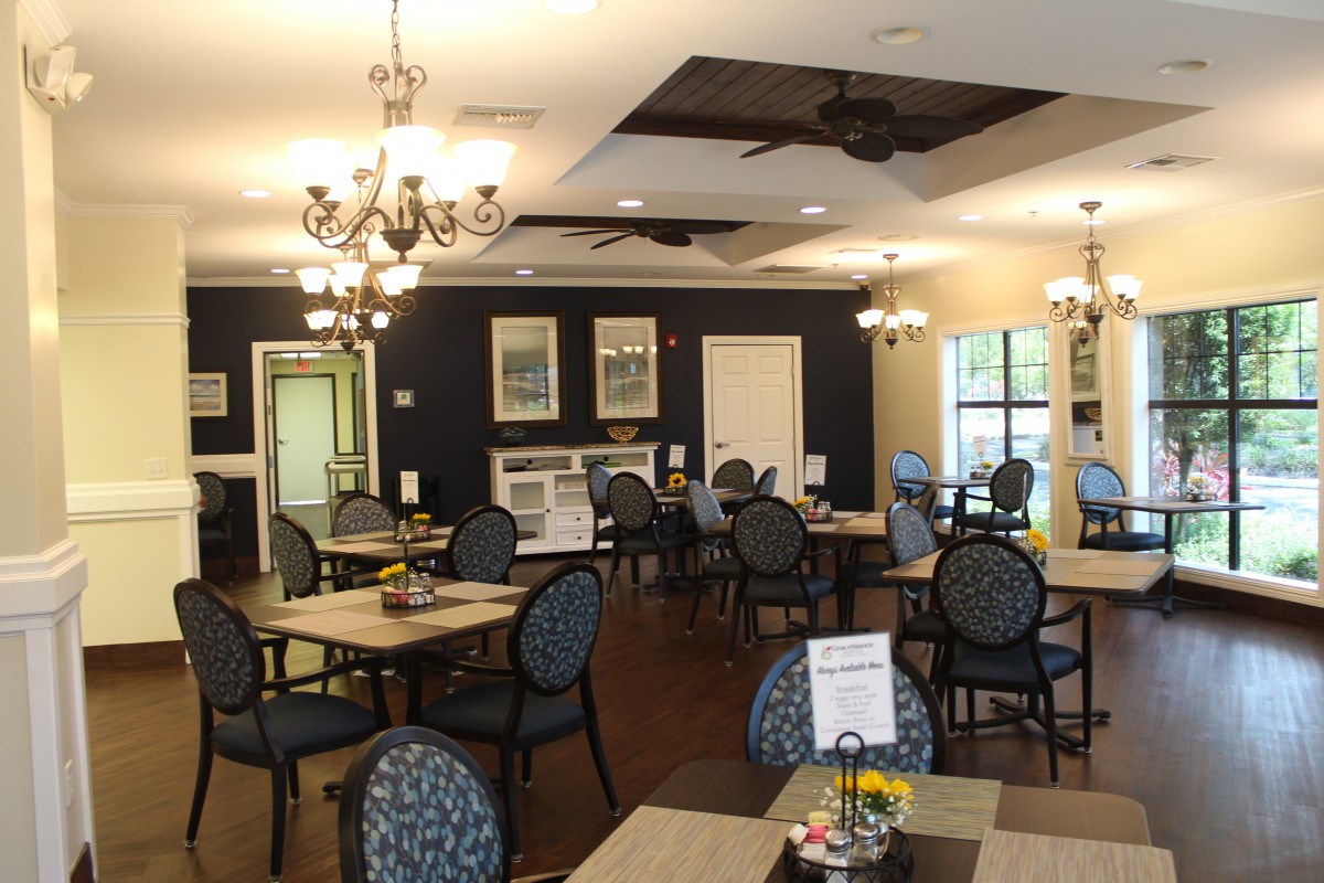 An elegant and well-decorated dining area with multiple tables and chairs, adorned with chandeliers.