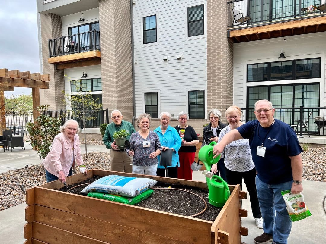 A group of seniors enjoys gardening together in a communal urban space.