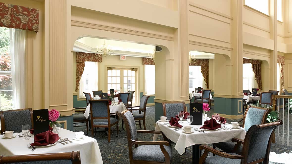 An elegantly set dining room with neatly arranged tables and chairs.