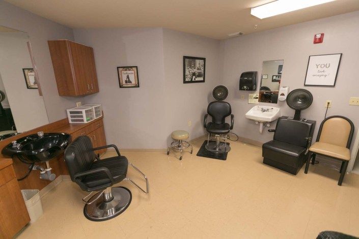A cozy hair salon interior with chairs and hairdressing equipment.