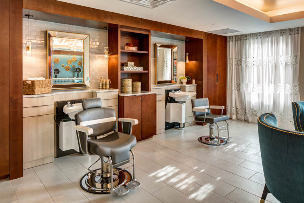 A modern barbershop interior with stylish chairs and mirrors.