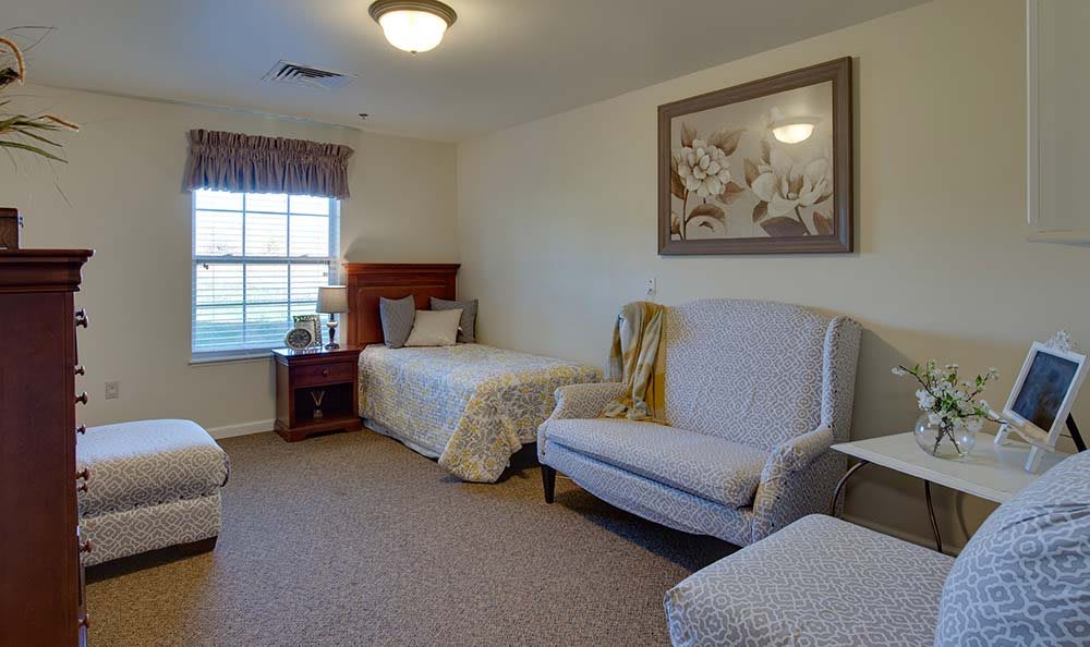 A cozy bedroom with a single bed, armchair, and decor.