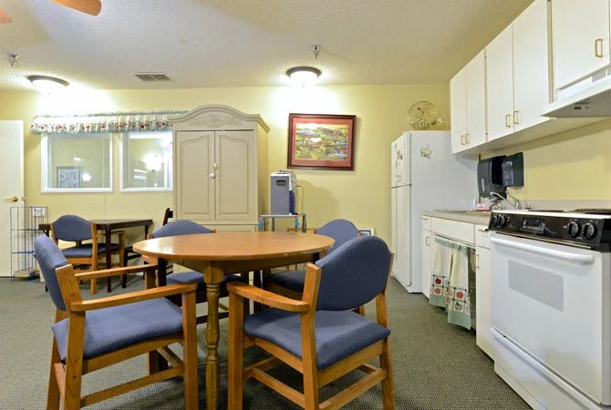 A cozy kitchen and dining area with a round table and chairs.