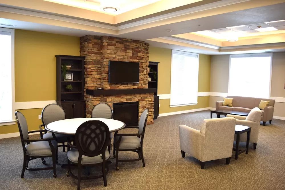A cozy living room with a stone fireplace and comfortable seating arrangements.