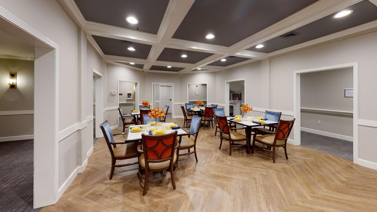 A well-lit dining area with arranged tables and chairs, featuring elegant interior design.