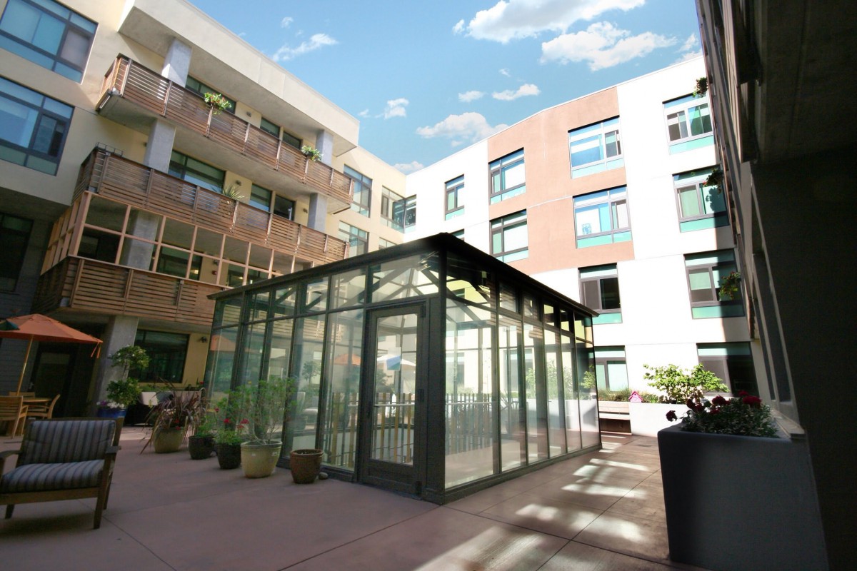 A modern courtyard with a glass structure surrounded by multi-story buildings.