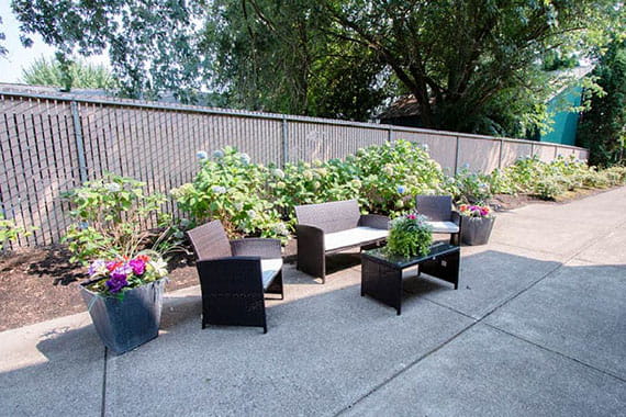 An outdoor patio area featuring wicker furniture and potted plants.