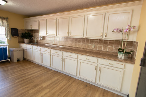 A spacious kitchen featuring cream-colored cabinets and a wooden floor.