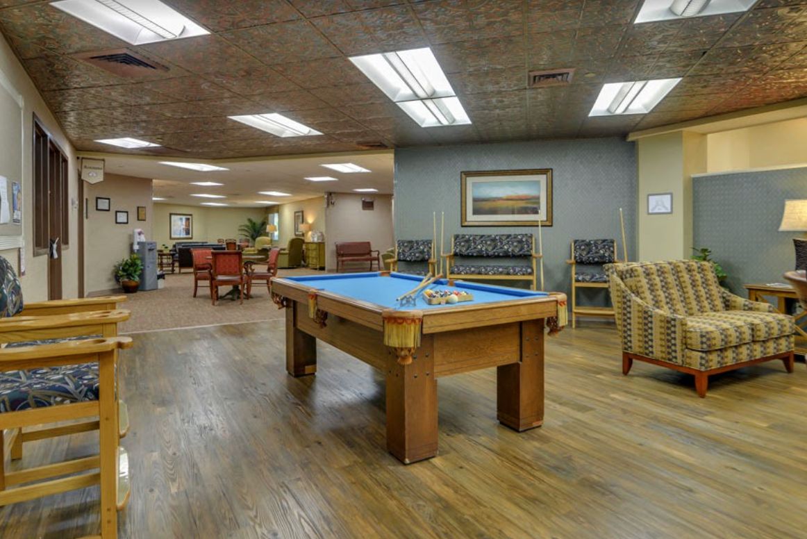 A spacious recreation room featuring a pool table and comfortable seating.