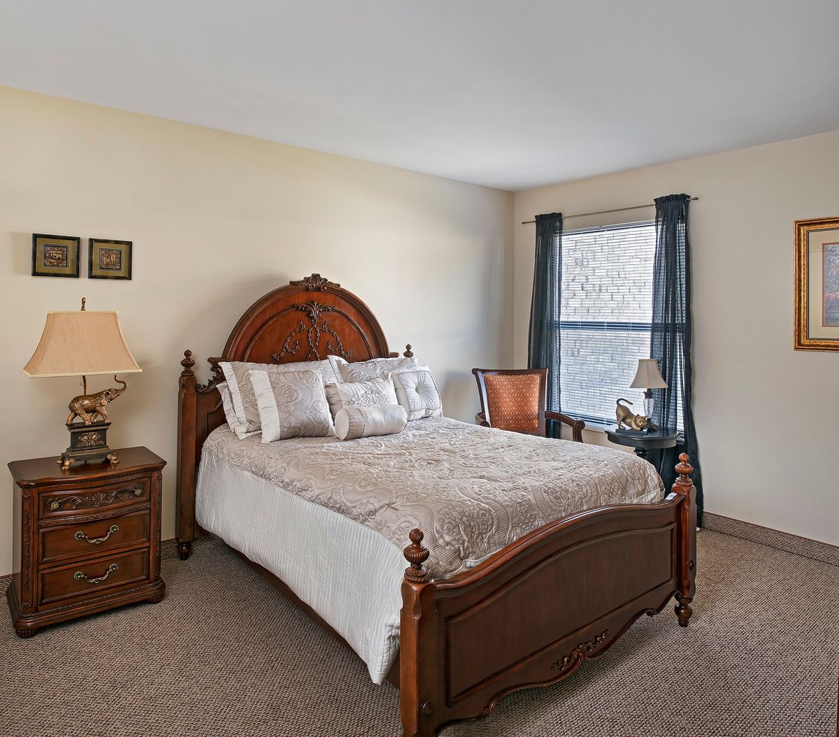 A cozy bedroom with traditional furniture and a large window.