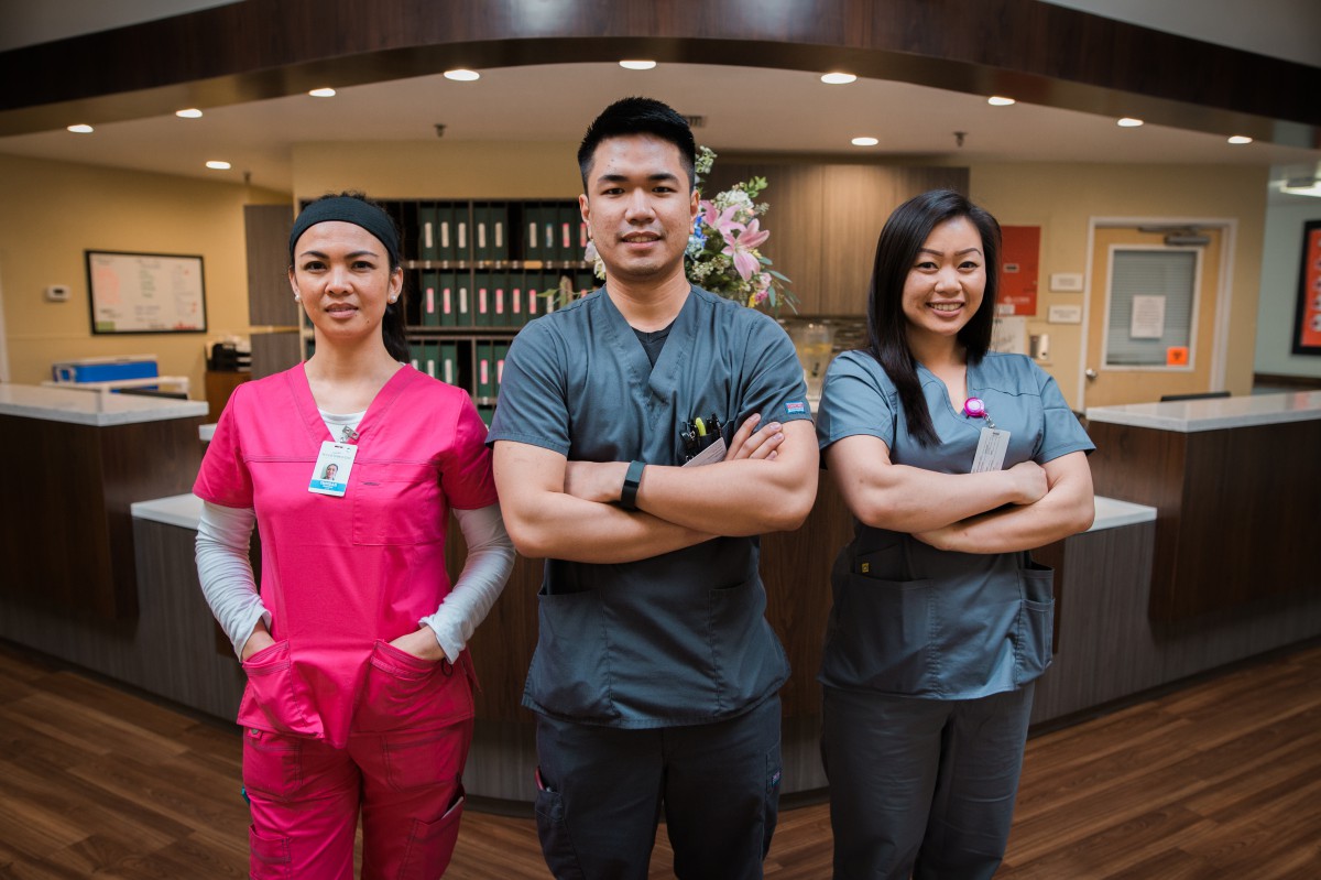 A team of medical professionals in scrubs standing confidently in a clinic.