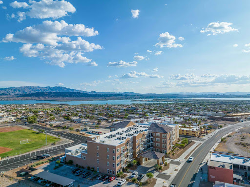 A stunning aerial view showcasing a vibrant city landscape against the backdrop of mountains and a serene body of water.