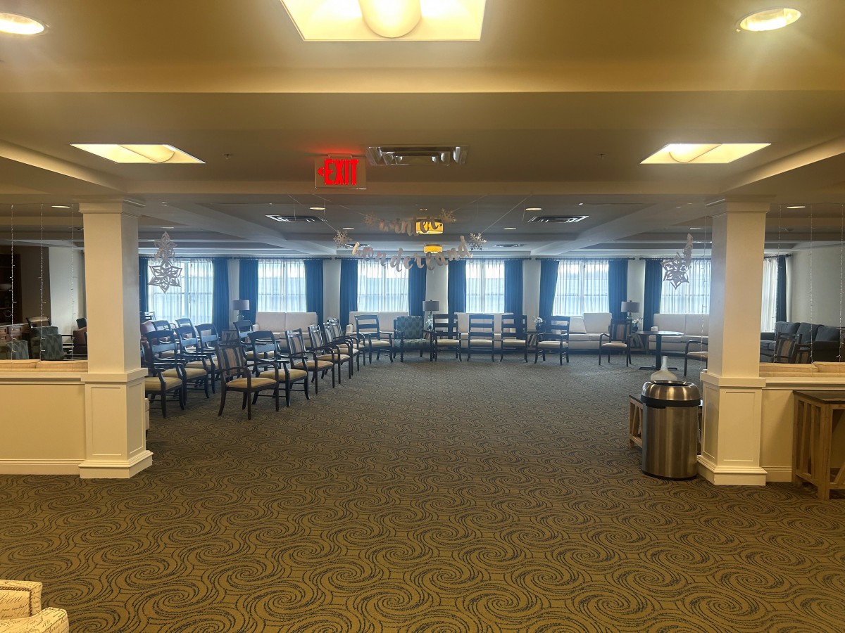 An empty conference room with rows of chairs and large windows.