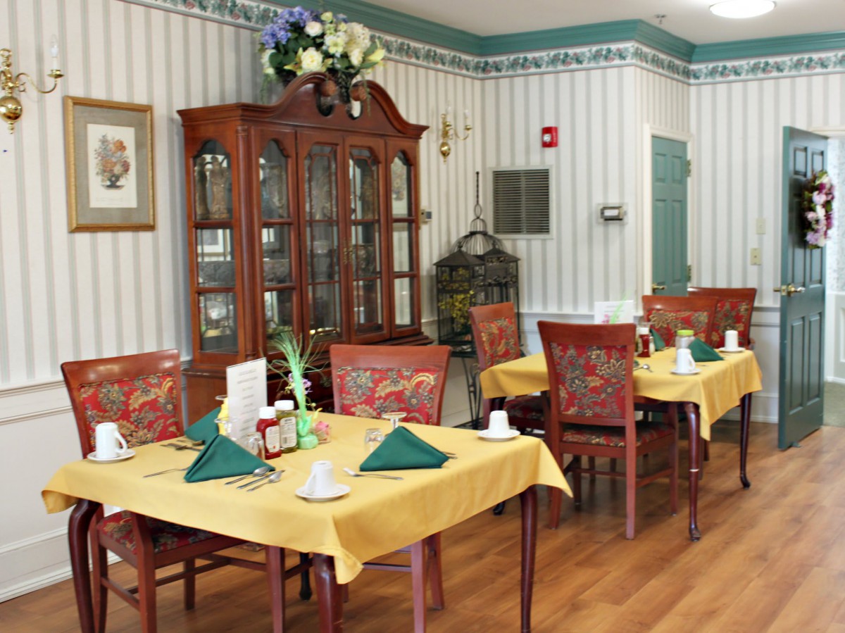 A quaint dining room with elegantly set tables and classic wooden furniture.