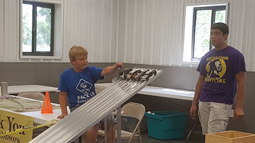 A child conducts an engineering experiment using a ramp and rolling objects, showcasing hands-on learning in a STEM setting.