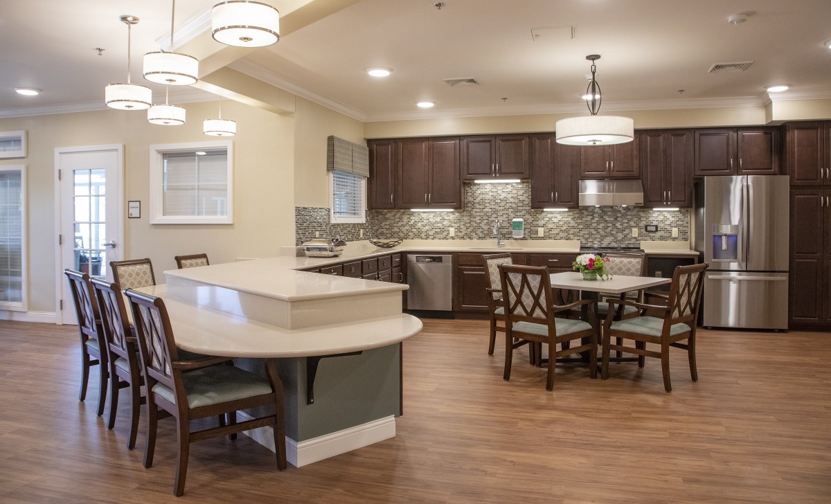 A modern kitchen and dining area with an open layout and wooden flooring.