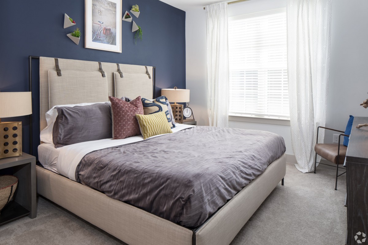 A modern bedroom with neutral tones and stylish decor.