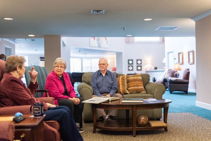 A group of seniors enjoying a conversation in a cozy living room setting.