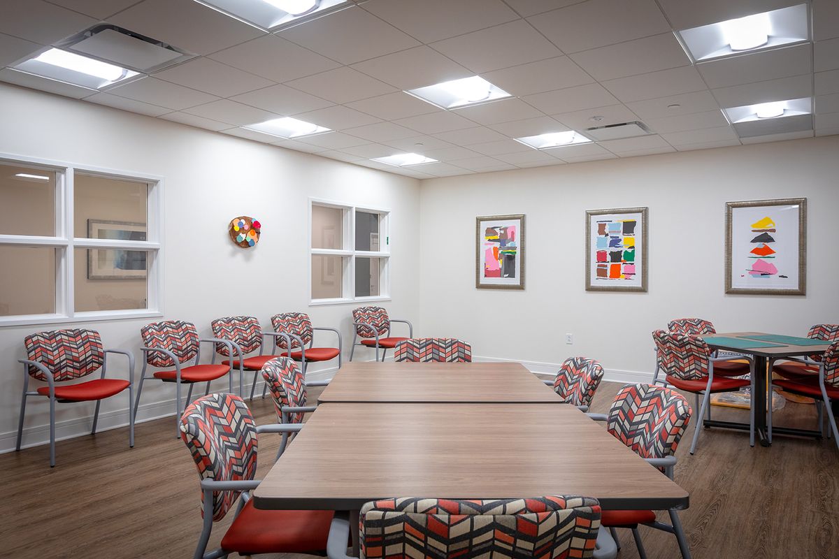 A well-lit meeting room with modern chairs and decorative artwork on the walls.