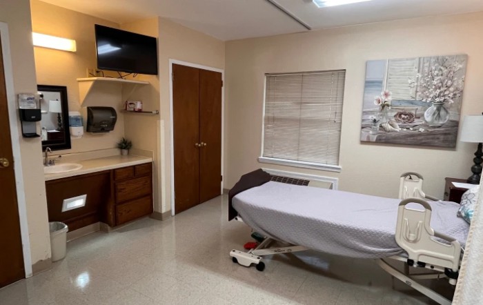 A clean and organized medical examination room with a treatment bed.