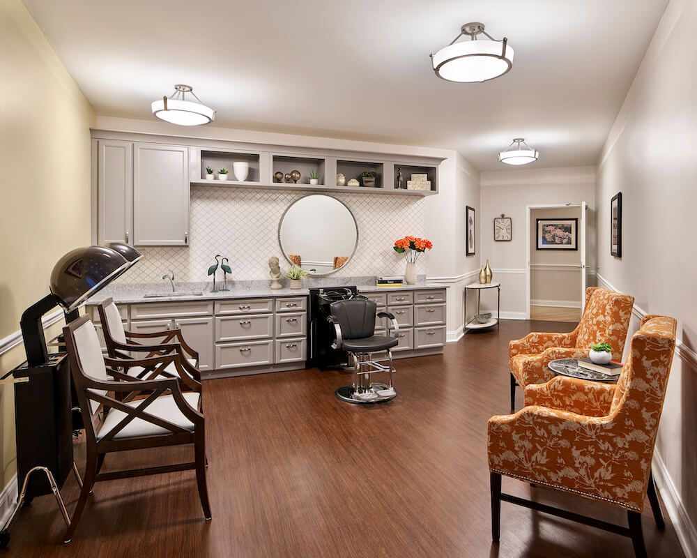 A well-decorated salon with a barber chair, mirrors, and comfortable seating.