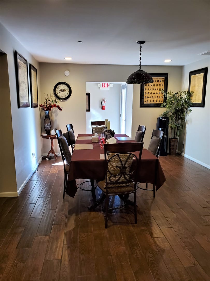 A well-decorated dining room with a large table, chairs, and wall artwork.