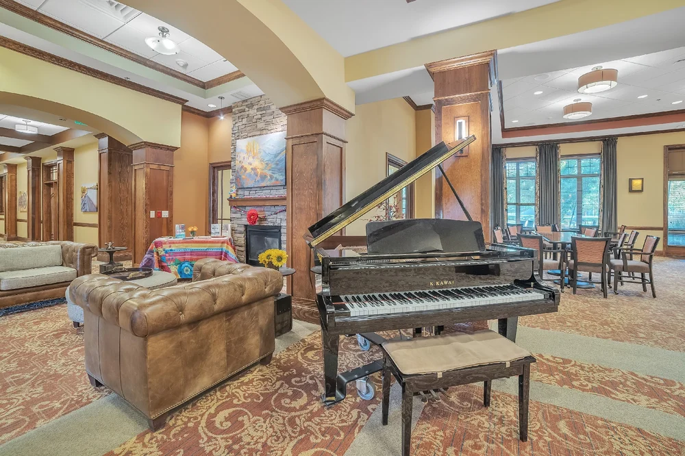 A luxurious living room featuring a grand piano, cozy sofa, and elegant decor.