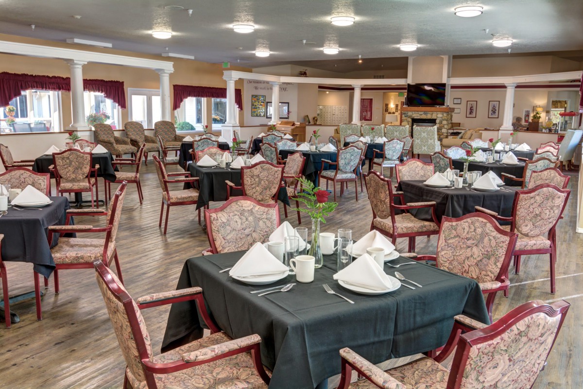 An elegantly set dining area with multiple tables and chairs, ready for guests.