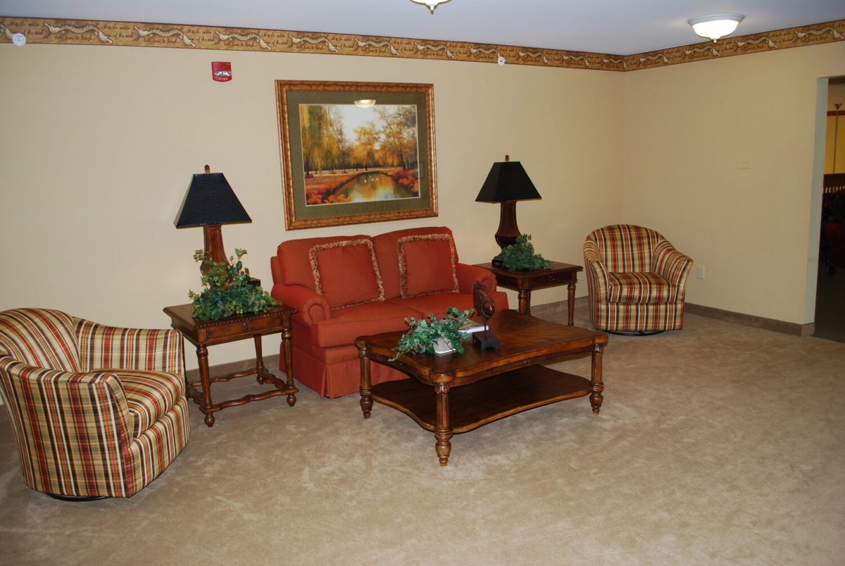 A cozy living room with a sofa, armchairs, and decorative elements.