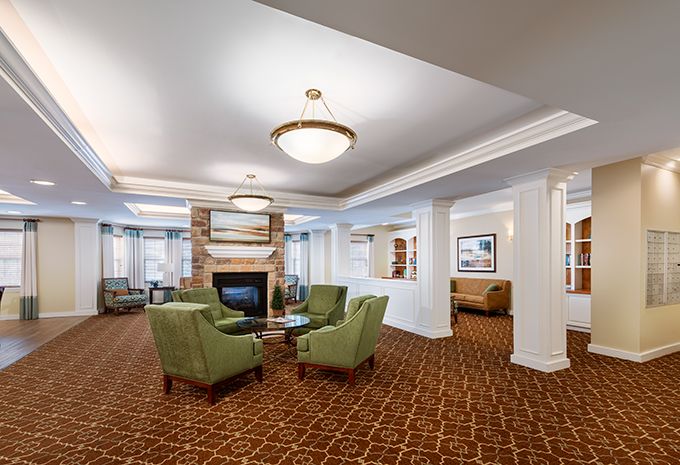 A spacious and elegant lobby with comfortable seating arranged around a fireplace.