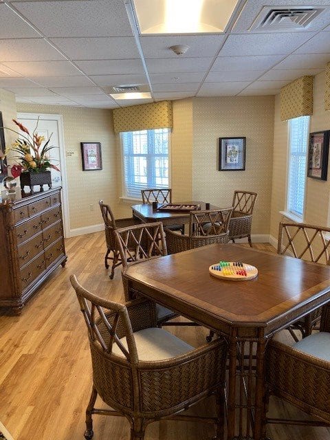 A cozy dining room with wooden tables and chairs, surrounded by warm decor and natural light.