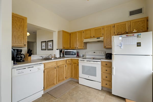 A cozy kitchen featuring wooden cabinets and standard appliances.