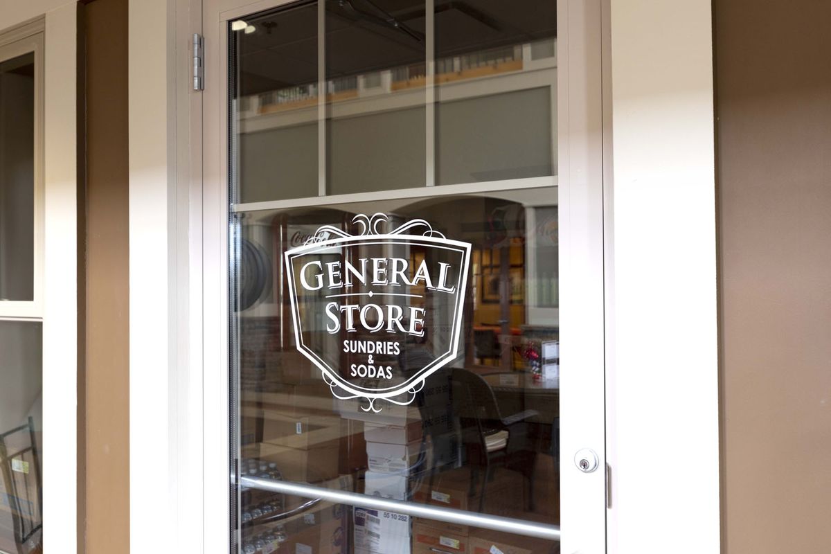 Entrance door of a general store with signage.