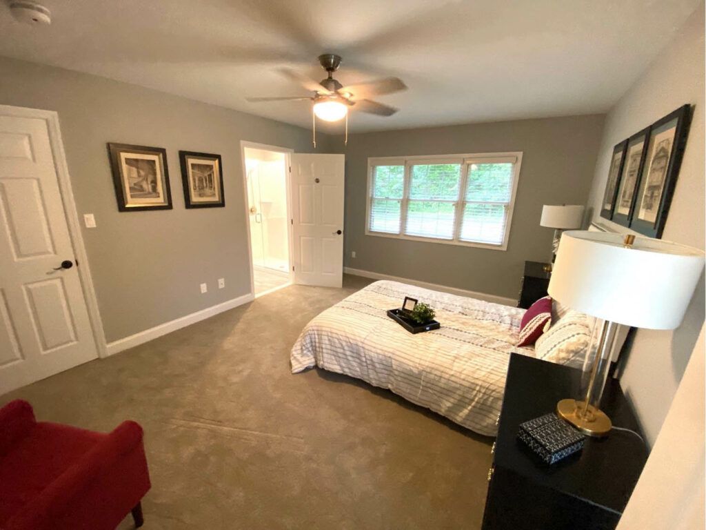 A cozy and modern bedroom with a comfortable bed, stylish decor, and a large window allowing natural light.