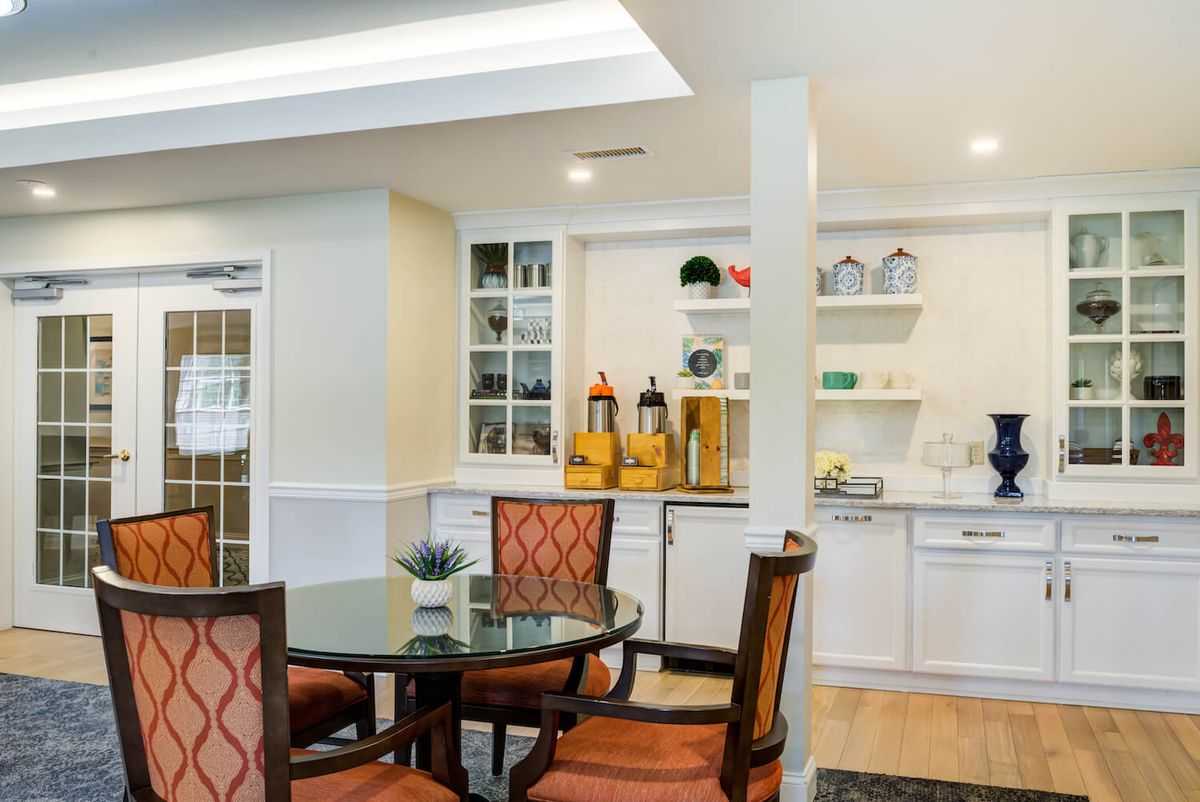 A cozy dining area with elegant furniture and a well-organized kitchen space.