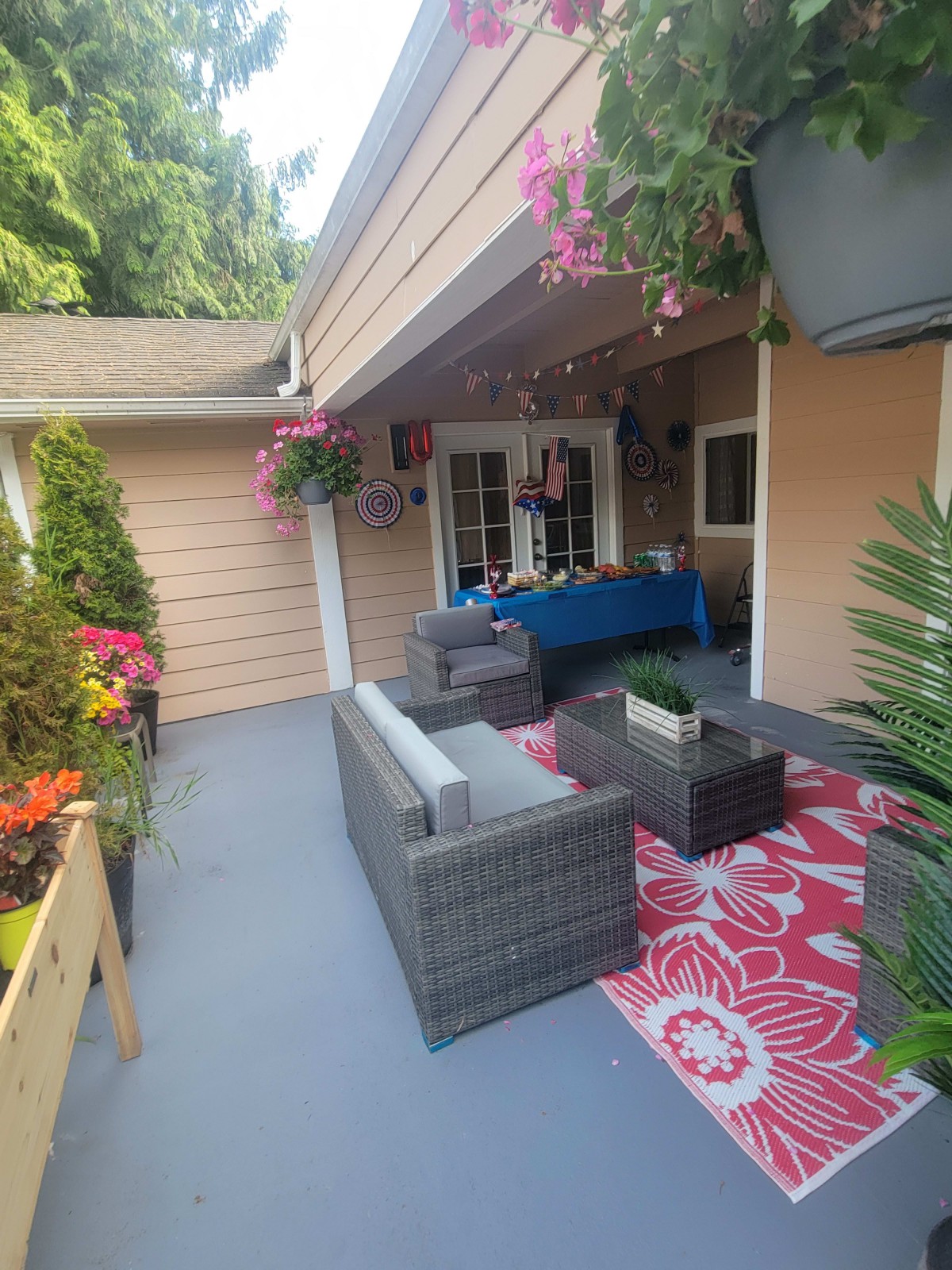 A cozy outdoor patio setup with comfortable seating, vibrant plants, and decorative accents.
