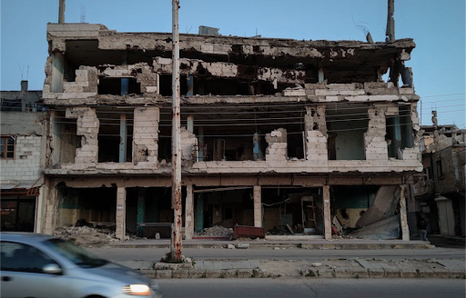 An abandoned and severely damaged building reflects the aftermath of conflict.