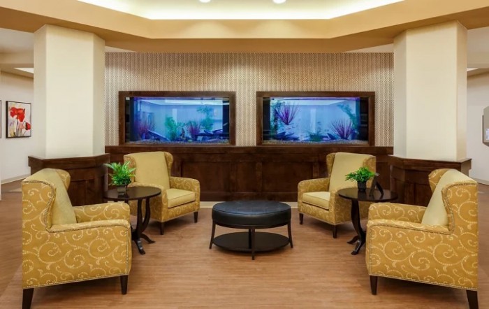 A cozy lobby area featuring comfortable armchairs and twin aquariums.