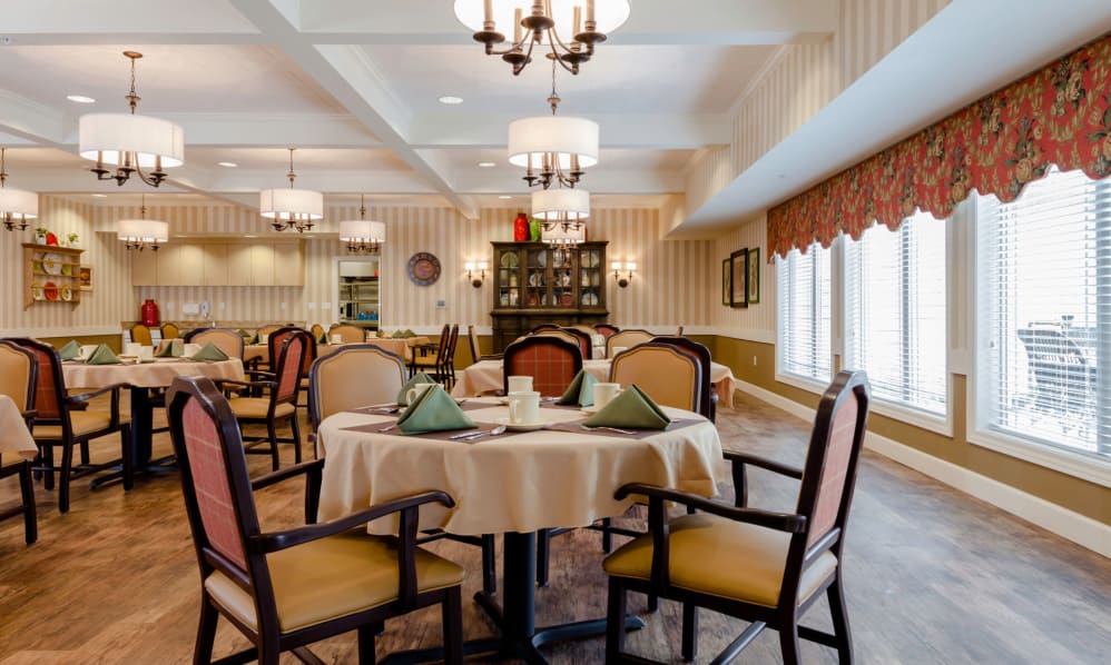 An elegant dining room with neatly arranged tables and chandeliers.