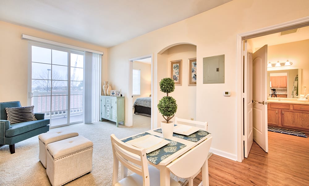 A bright and modern apartment featuring a cozy dining area with natural light flooding through large windows.