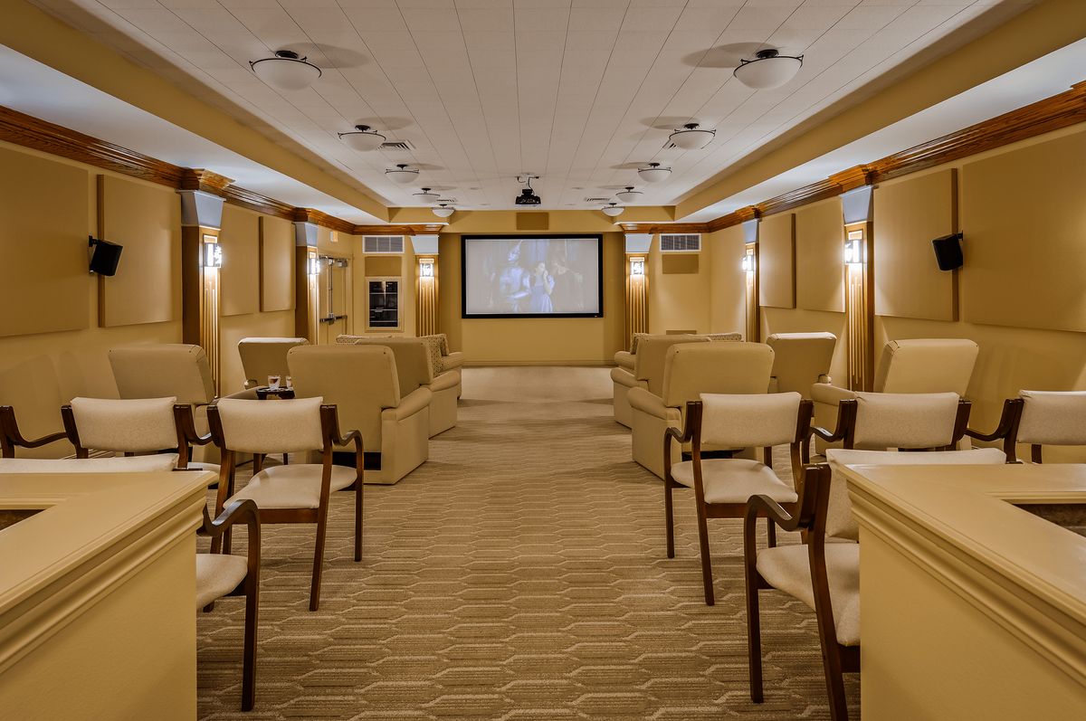 A luxurious home theater with plush seating and a large screen.