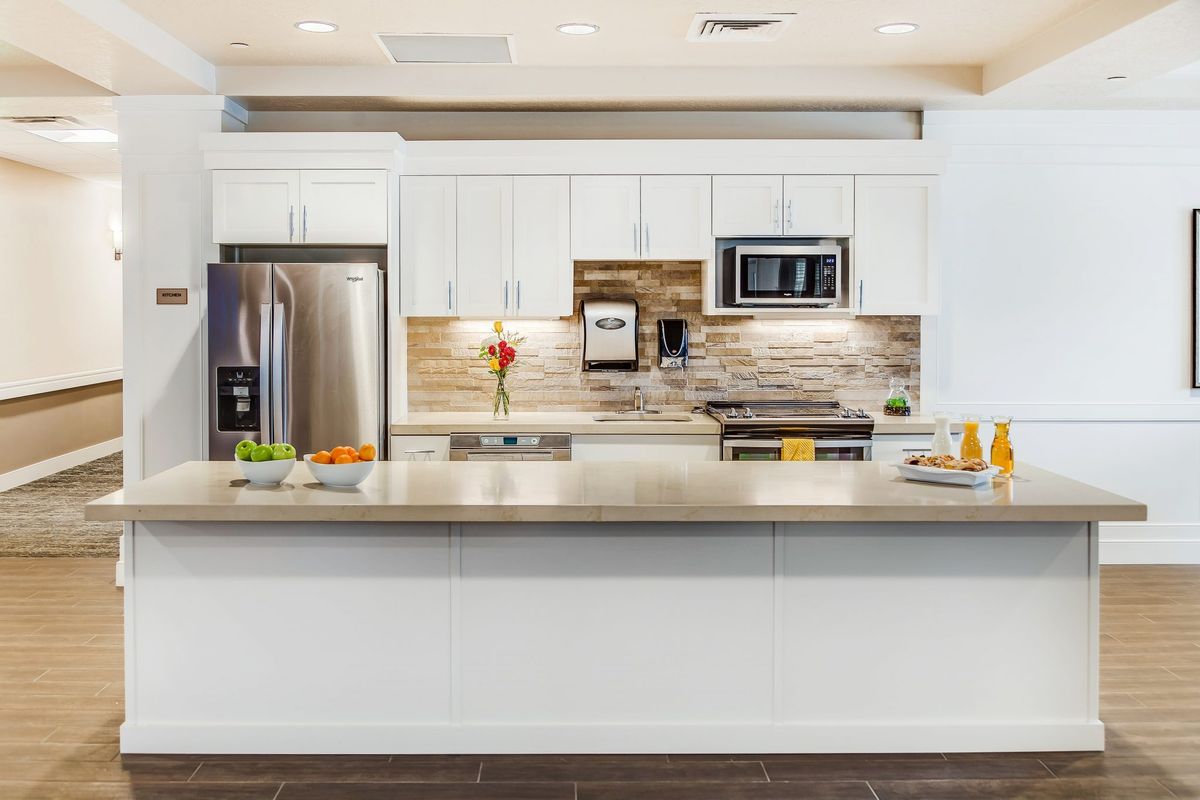 A modern kitchen with white cabinetry, stainless steel appliances, and a stylish backsplash.