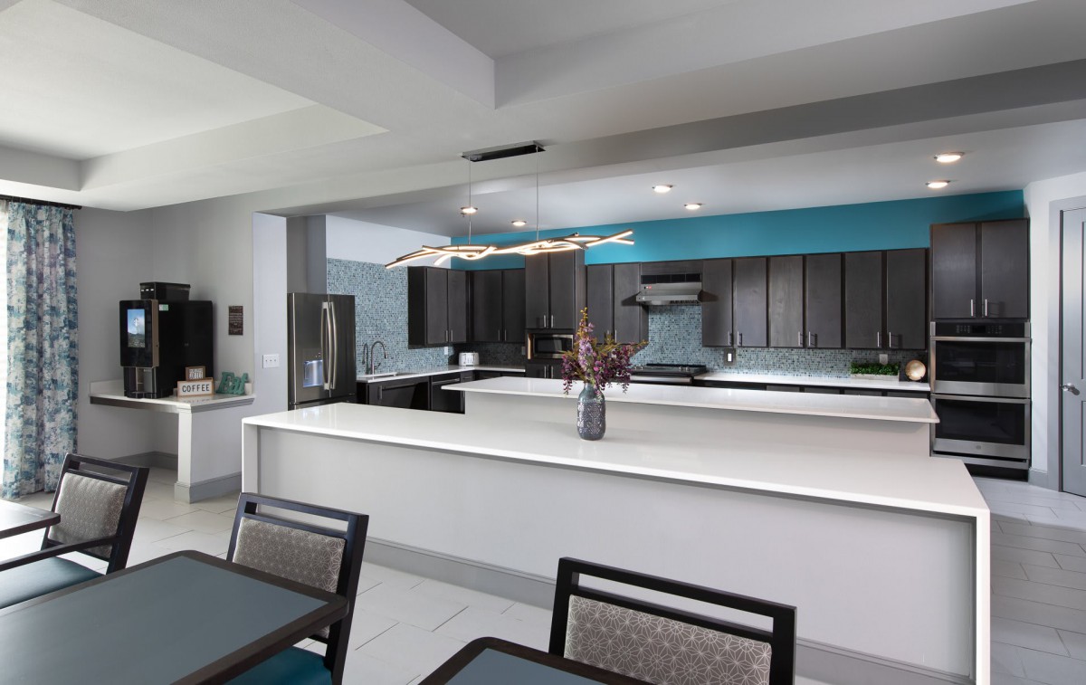 A modern kitchen space with a large countertop and dining area.
