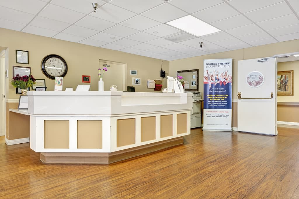 A modern reception area with a clean and professional design featuring a central desk.