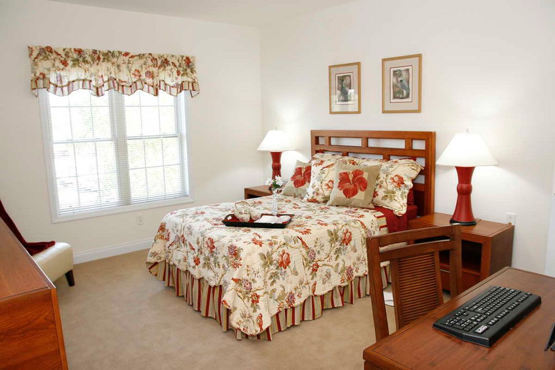 A cozy bedroom with floral-patterned bedding and warm lighting.