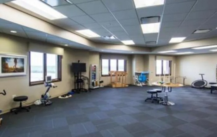 A spacious physical therapy and rehabilitation center equipped with various exercise machines.
