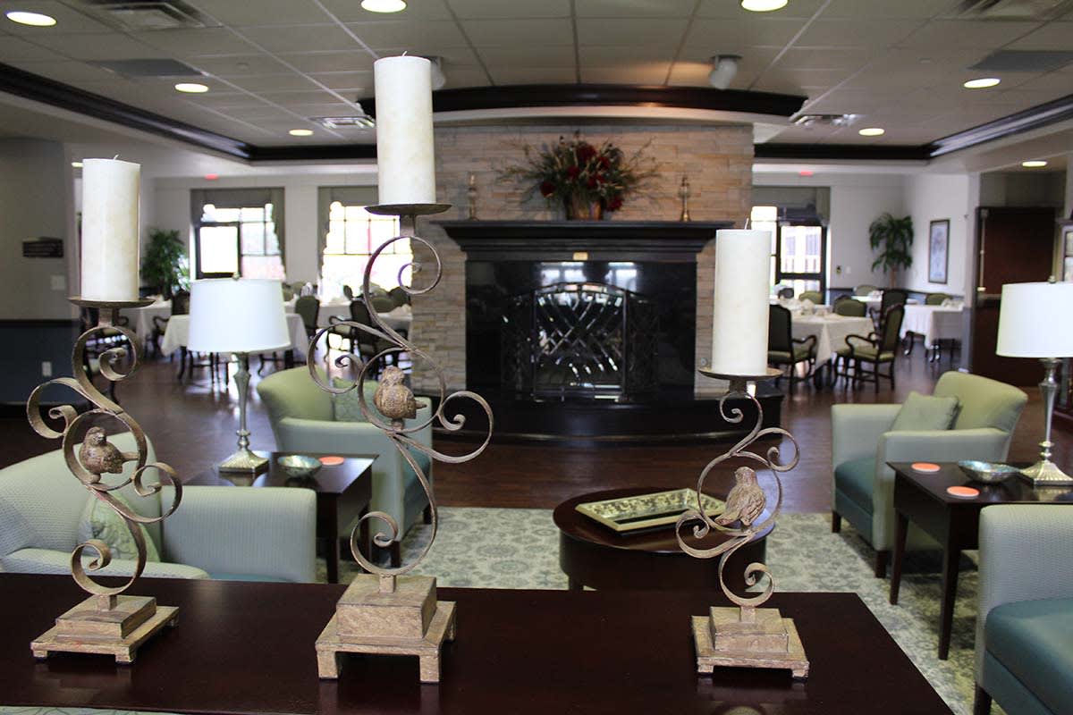 A spacious lounge area featuring modern decor with a central fireplace and stylish candle holders.