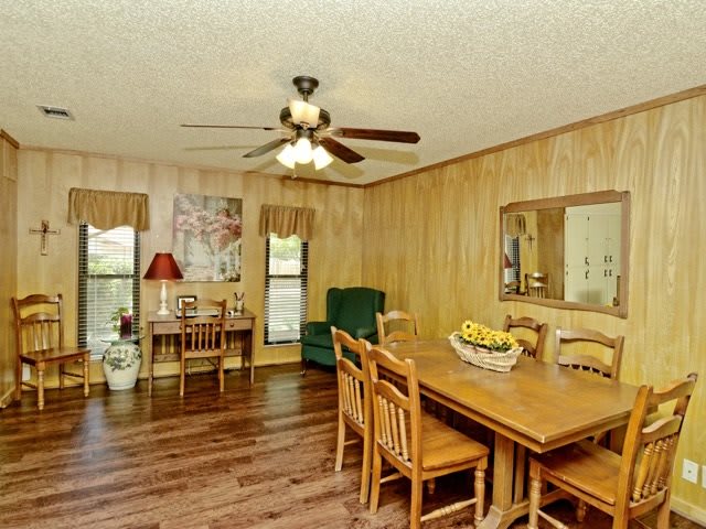A cozy dining area with wooden furniture and wood paneled walls.