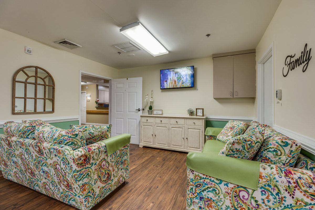 A cozy waiting room with colorful furniture and a television mounted on the wall.