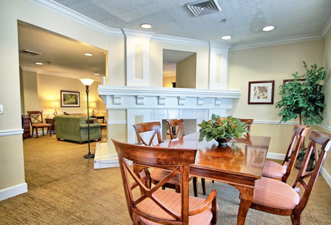 A cozy dining area with wooden furniture and elegant decor, adjacent to a living room space.
